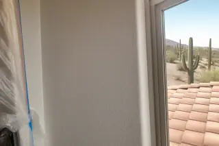 Knockdown drywall texture matching on an interior wall with a view of desert landscape in Phoenix, AZ.