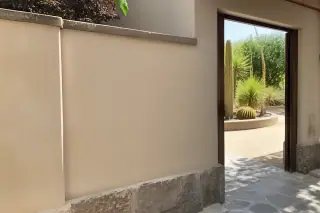 Smooth plaster wall repair blending into a historic wall with desert landscaping visible in Phoenix, AZ.