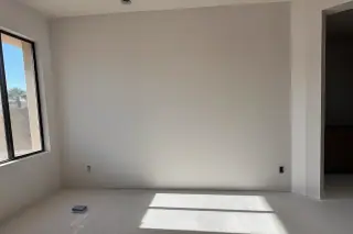 Finished drywall water damage repair showing a feathered seam and sanding block on the floor of a home in Phoenix, AZ.