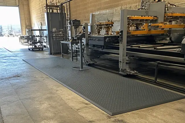 Textured rubber anti-fatigue mats installed on a concrete floor at an industrial facility in Phoenix, AZ.