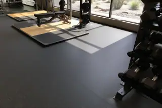 High-density rolled rubber flooring seams under gym equipment with desert landscaping visible in Phoenix, AZ.