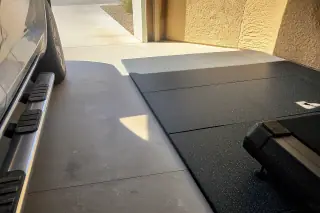 Interlocking rubber floor tiles installed next to a parked car in a Phoenix, AZ garage.