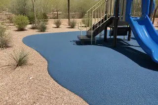 Poured-in-place rubber safety surfacing around a playground in Phoenix, AZ, with desert landscaping nearby.