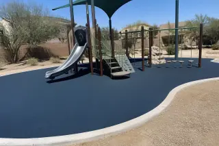 Poured-in-place rubber safety surfacing installed around a playground in Phoenix, AZ.