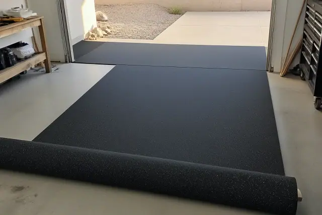 Rolled rubber flooring being installed on a concrete garage floor in Phoenix, AZ.