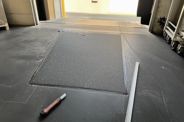 A rubber flooring patch repair near a warehouse loading dock in Phoenix, AZ.