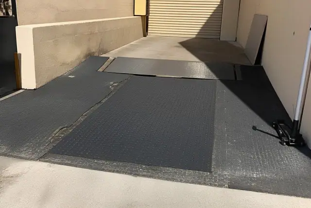 Contractor repairing damaged industrial rubber flooring at a loading dock in Mesa, AZ.