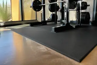 New rubber gym flooring installed under a squat rack with bright desert sunlight in Phoenix, AZ.