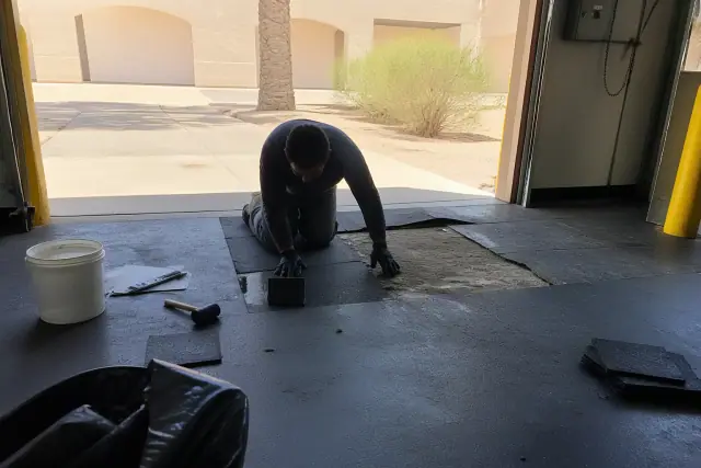 Contractor repairing industrial rubber flooring near a loading dock in Phoenix, AZ.