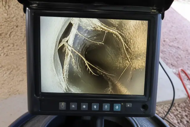 Sewer camera monitor displaying tree roots and a collapsed pipe during an inspection in Phoenix, AZ.