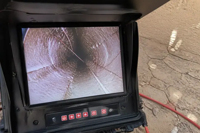 Sewer camera monitor showing pipe cracks and roots during an inspection in Phoenix, AZ.