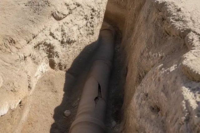 Deep trench revealing cracked terra cotta sewer pipe during a residential excavation project in Phoenix, AZ.
