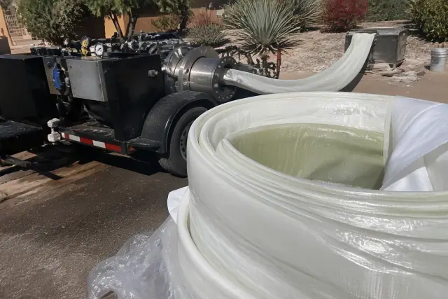 Resin-coated pipe liner and a hydraulic inversion machine at a sewer pipe lining job site in Phoenix, AZ.