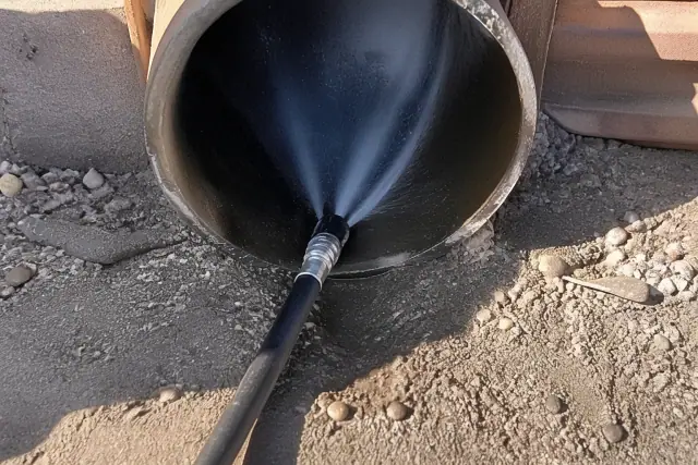 High-pressure hose nozzle cleaning debris from an industrial sewer pipe in Phoenix, AZ.