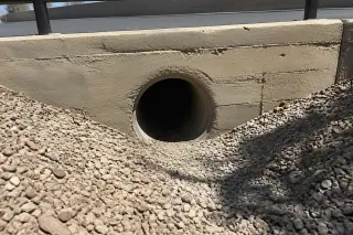 Cleaned industrial drainage pipe opening surrounded by desert gravel at a commercial property in Phoenix, AZ.