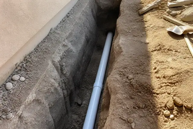 New sewer pipe section being installed in a residential trench in Phoenix, AZ.