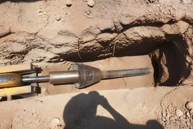 A hydraulic bursting head positioned in an entry pit for trenchless sewer repair at a jobsite in Phoenix, AZ.
