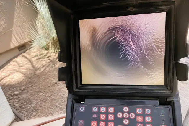 Portable monitor showing a sewer camera inspection of pipe blockages at a jobsite in Phoenix, AZ.