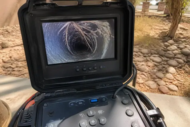 A sewer camera monitor showing pipe conditions and tree roots during a commercial inspection in Phoenix, AZ.