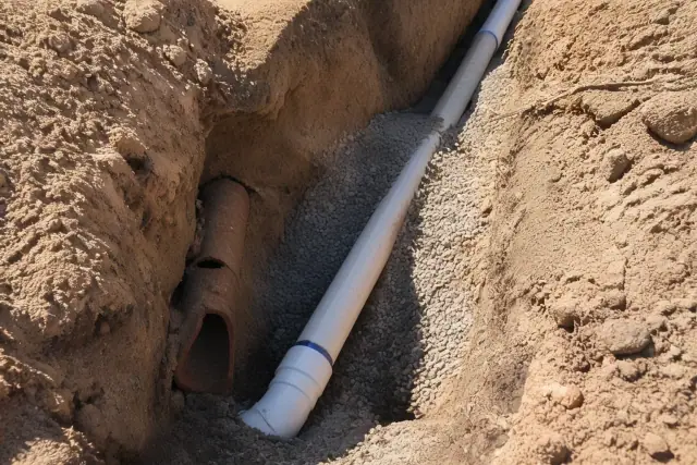 Sewer line replacement in a deep trench with new piping and soil backfill at a jobsite in Chandler, AZ.