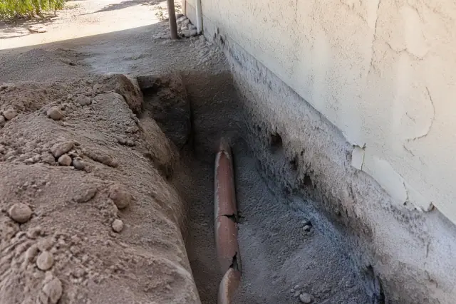 Deep trench showing a sewer pipe replacement at a construction site in Phoenix, AZ.