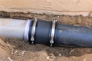 Close-up of an underground pipe coupling with heavy-duty gaskets at a Phoenix, AZ worksite.