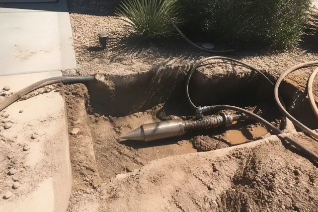 Hydraulic bursting head in a trenchless pipe repair pit during a sewer line project in Phoenix, AZ.