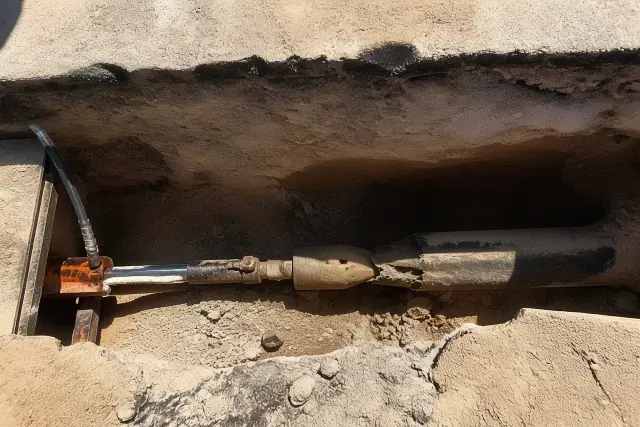 Hydraulic bursting head inside a trenchless pipe replacement pit in Peoria, AZ.