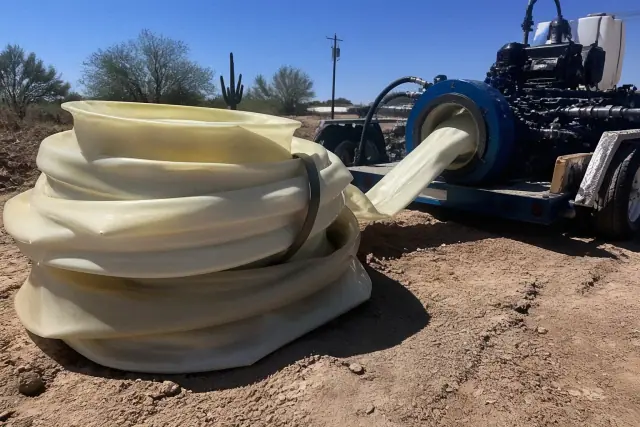 Resin-coated pipe liner and hydraulic inversion machine at a job site in Phoenix, AZ.