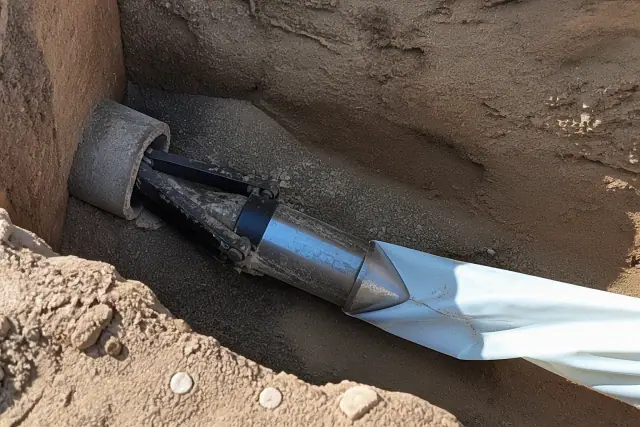 Hydraulic bursting head pulling a new liner through a pipe in a trenchless entry pit in Phoenix, AZ.