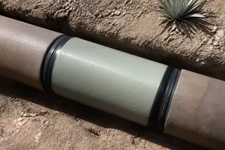 Seamless cured pipe coupling with industrial gaskets surrounded by desert gravel in Phoenix, AZ.