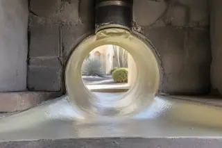 Seamless cured resin liner inside a restored floor drain junction in a Phoenix, AZ utility room.