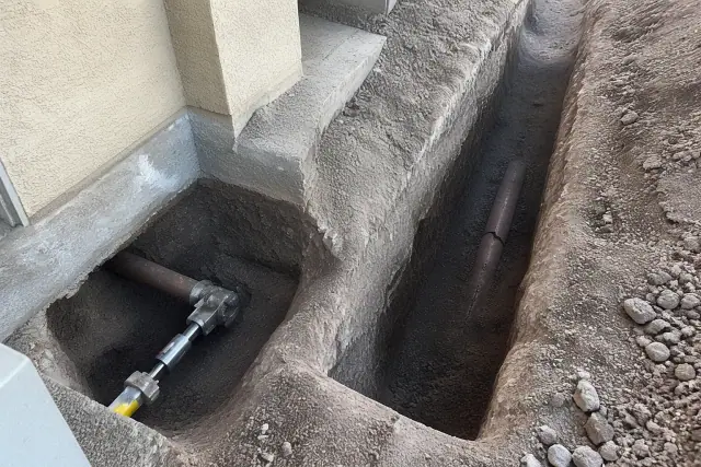 Excavation showing a cracked pipe and hydraulic bursting head for trenchless repair at a site in Phoenix, AZ.