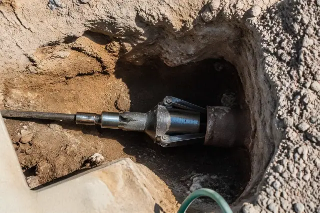 Hydraulic bursting head inside a trenchless sewer repair entry pit in Goodyear, AZ.