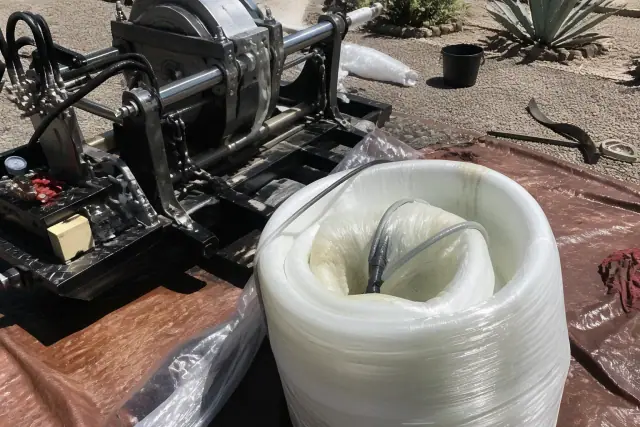 Resin-coated liner being prepared for sewer pipe lining next to hydraulic equipment at a jobsite in Phoenix, AZ.