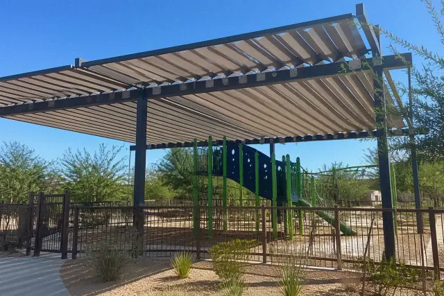 Adjustable louvered shade structure over a children's playground in Phoenix, AZ.