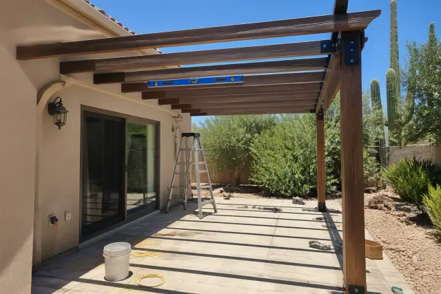 Attached pergola installation in progress on a residential stone patio in Phoenix, AZ.