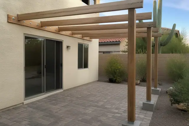 Attached pergola ledger bolt and footing connection on a stucco wall at a Phoenix, AZ residential backyard patio.