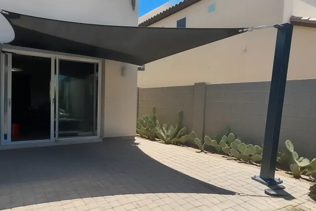 Cantilever shade structure with steel mounting on a residential backyard patio in Tempe, AZ.