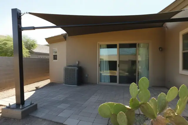 Cantilever shade structure over a paved backyard patio with prickly pear cactus in Scottsdale, AZ.
