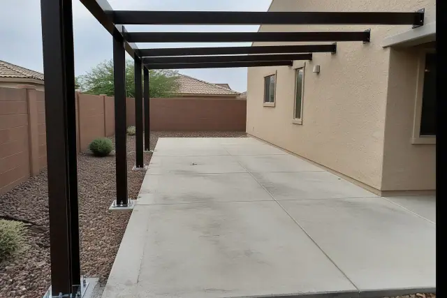 Steel carport mounting brackets bolted to a concrete driveway in Surprise, AZ.