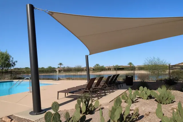 Structural shade sail installed over a commercial pool deck with xeriscaping in Phoenix, AZ.