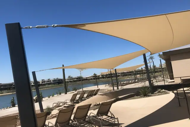 Commercial shade sails installed over a pool deck with desert landscaping in Phoenix, AZ.