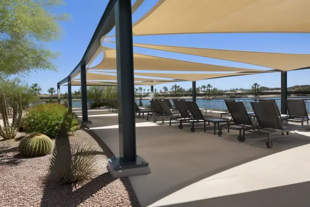Commercial shade structures with tensioned fabric panels over lounge chairs at a pool deck in Scottsdale, AZ.