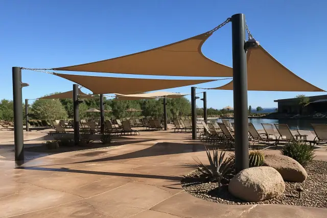 Commercial shade structures over a pool deck with desert landscaping in Goodyear, AZ.