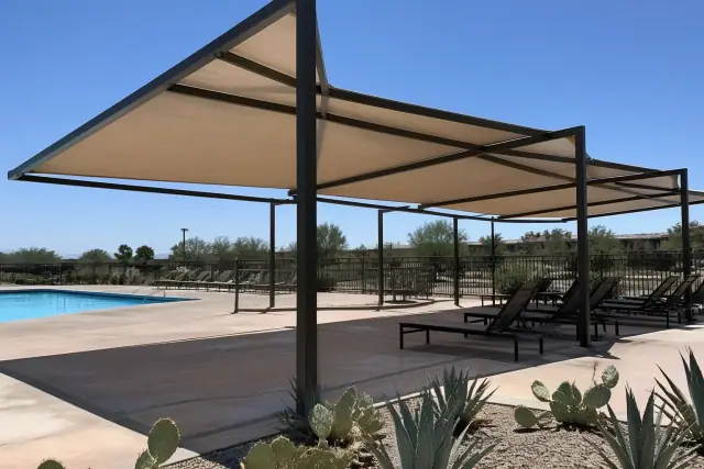 Commercial shade structures over a pool deck with desert landscaping in Phoenix, AZ.