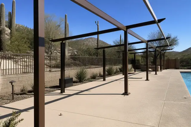 Commercial shade structures for a pool deck installation in Phoenix, AZ with cacti in the background.