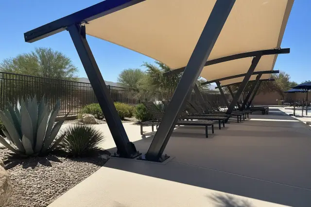 Commercial shade structure over a pool deck with desert agave landscaping in Mesa, AZ.