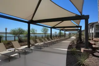 Powder-coated metal shade structure with fabric panels over a commercial pool deck in a Phoenix, AZ backyard.