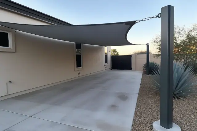 Triangular shade sail installed over a residential driveway in Phoenix, AZ with visible tensioning hardware.